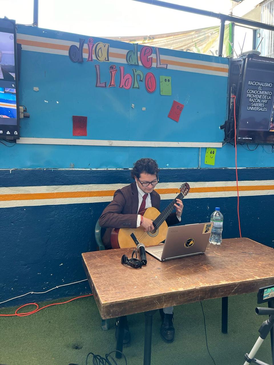 Franco Farías tocando la guitarra durante una actividad en San Juan Sacatepéquez, mayo de 2024